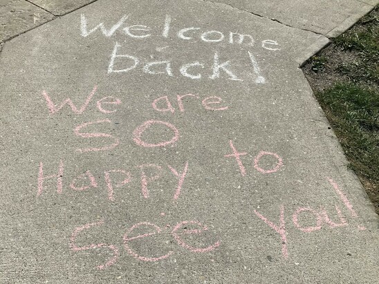 A picture of chalk art in front of EMP saying that we are happy to see everyone!