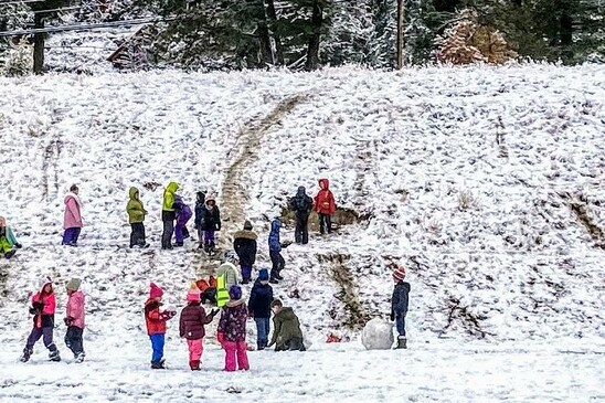 Students playing on snowy hill